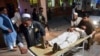 FILE - A wounded man is brought by stretcher into a hospital in Jalalabad city, capital of Nangarhar province, east of Kabul, June 16, 2018. 
