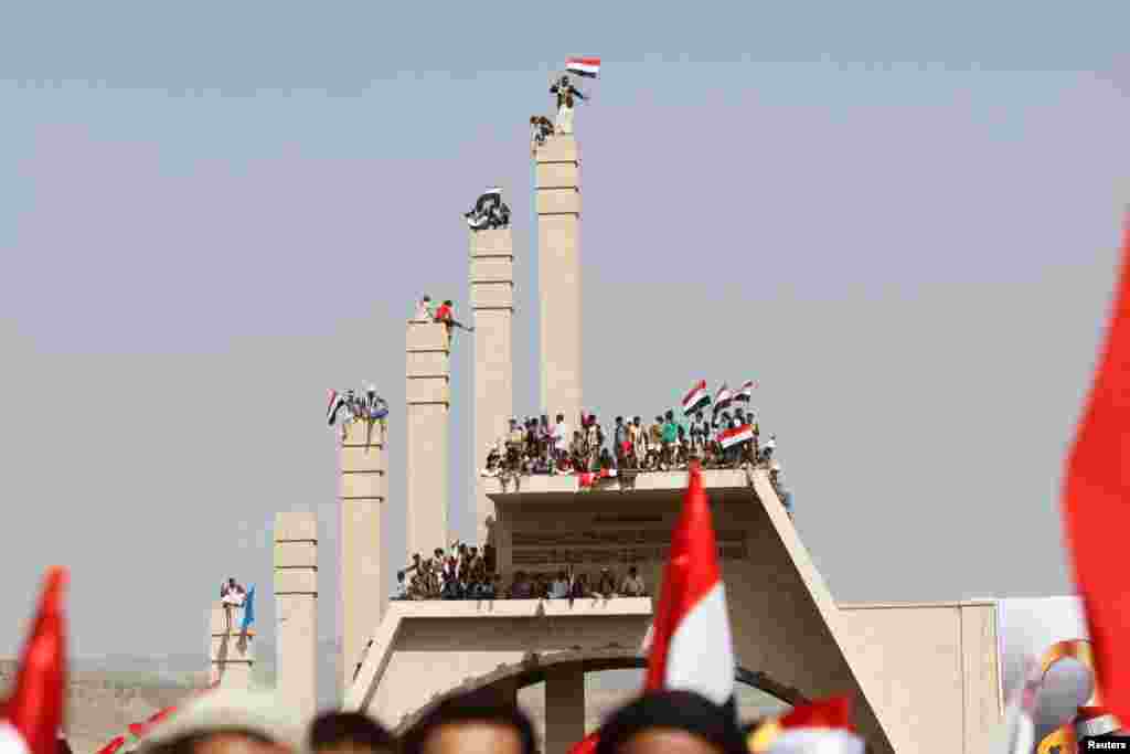 Warga membawa bendera nasional Yaman pada upacara memperingati hari Reunifikasi di Sana&#39;a.