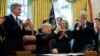 President Donald Trump holds up a pen during a signing ceremony of the "Cybersecurity and Infrastructure Security Agency Act," in the Oval Office of the White House, Nov. 16, 2018, in Washington.