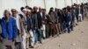 FILE - Afghan men line up to cast their votes during the parliamentary election at a polling station in Kabul, Afghanistan, Oct. 21, 2018. 