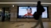 A man walks past screens displaying a television news programme showing an image of Kenji Goto, one of two Japanese citizens taken captive by Islamic State militants, on a street in Tokyo, January 25, 2015.