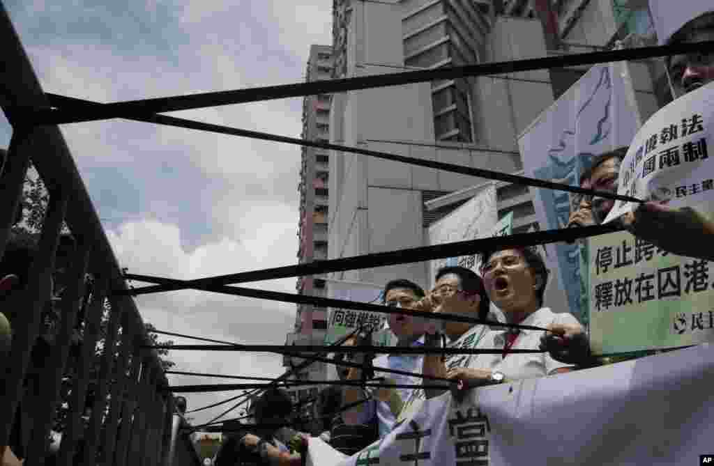 Para demonstran pro-demokrasi memajang pita hitam di depan kantor pemerintah China di Hong Kong, sebagai protes atas penangkapan aktivis.&nbsp;