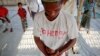 A Rohingya Muslim with the word "Rohingya" written on his T-shirt prays with others at a makeshift mosque at a camp for those displaced by violence, near Sittwe April 28, 2013.
