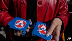 ARCHIVO - Miembros de organizaciones LGBTQ+ reparten calcomanías que dicen en español "Apruebo" para mostrar su apoyo a un nuevo borrador de la Constitución en Santiago, Chile, el 15 de agosto de 2022, que luego fue rechazado por los votantes en un plebiscito.