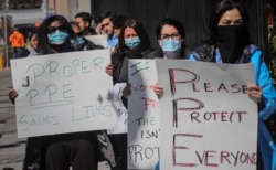 FILE - Nurses at Montefiore Medical Center Moses Division in New York hold an "urgent community speak out" demanding N95s and other critical personal protective equipment to handle the COVID-19 outbreak, April 2, 2020.