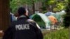 Un agente de la policía de la Universidad George Washington supervisa la zona en la que los estudiantes mantienen una protesta pro-Palestina por la guerra entre Israel y Hamás, el 26 de abril de 2024, en Washington. 