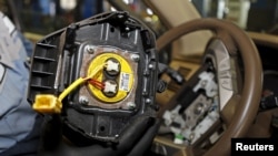 Un inflador defectuoso de bolsas de aire Takata es retirado de un vehículo Honda Pilot en la mecánica de AutoNation Honda, un distribuidor autorizado de esos vehículos en Miami, Florida.