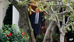 White House chief of staff John Kelly opens the door of the Oval Office for President Donald Trump, July 31, 2018, as Trump leaves the White House in Washington, en route to Tampa, Florida, to speak at a rally.
