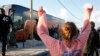 A volunteer waves to migrant minors in a bus during their transfer by French authorities to reception centers across the country at the end of the dismantlement of the camp called "the Jungle" in Calais, France, Nov. 2, 2016. 